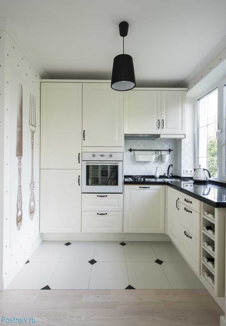 Угловая кухня в панельном доме. Белые фасады, черная столешница из искусственного камня. Фото ремонта
