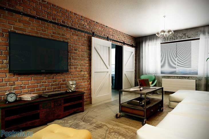 Интерьер 3-комнатной квартиры. Гостиная в стиле лофт. Кирпичная стена и двери купе. Фото