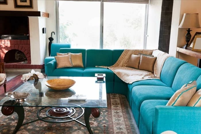 Бирюзовый угловой диван в интерьере гостиной